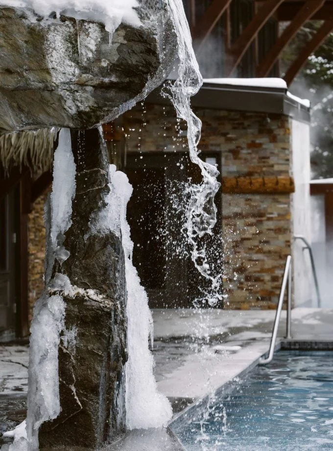 Chute d’eau glacée près d’une piscine extérieure