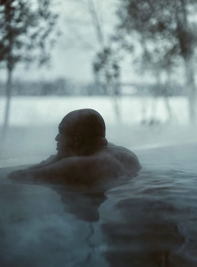 Homme dans un bain chaud extérieur brumeux
