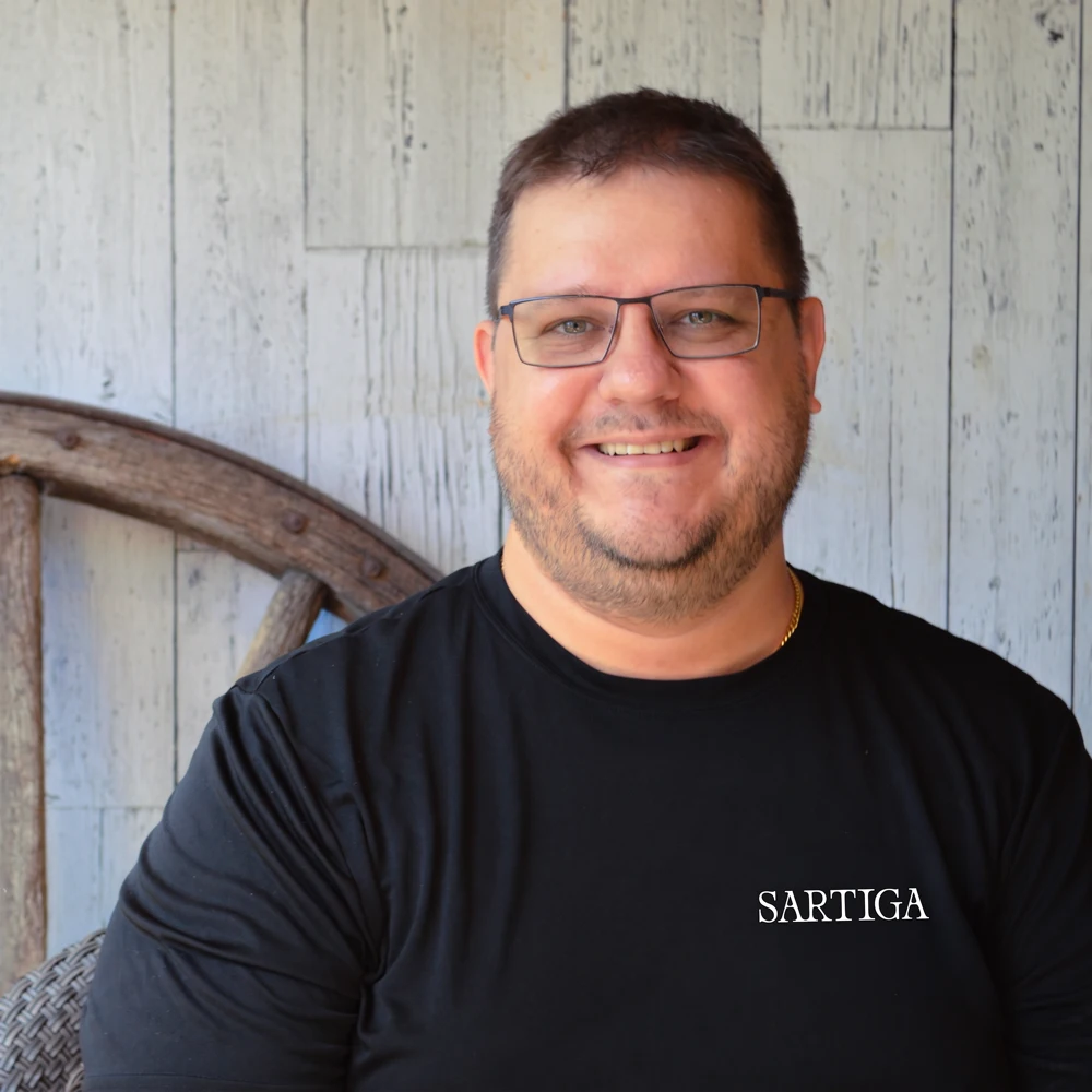 Homme souriant portant un chandail noir Sartiga